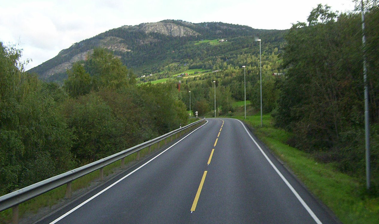 Icon showing a paved roadway through a rural landscape, representing pavement design and analysis.